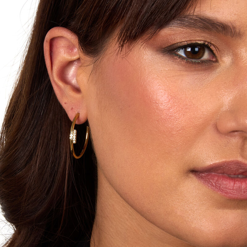 Ženske naušnice tipa creole s T-logom od nehrđajućeg čelika, pozlačene, ukrašene bijelim kristalima, TRUSSARDI